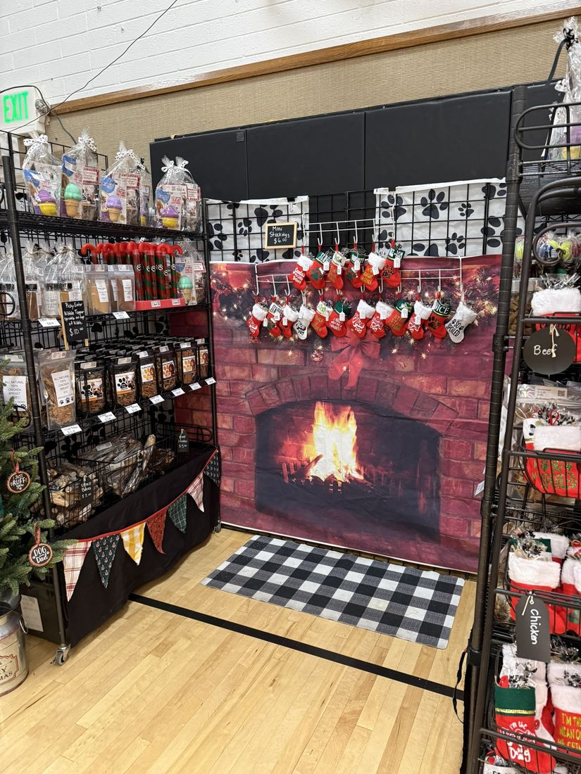 A vendor booth styled around a red brick fireplace backdrop with stockings and holiday treats